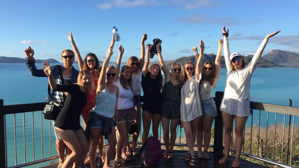 lookout hands up a group of people standing next to a body of water
