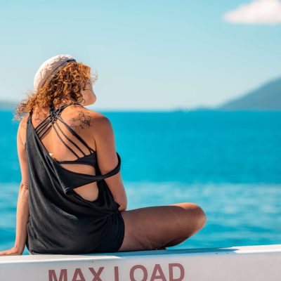 a woman standing in front of a body of water