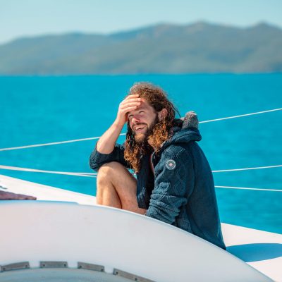 a man and woman sitting next to a body of water