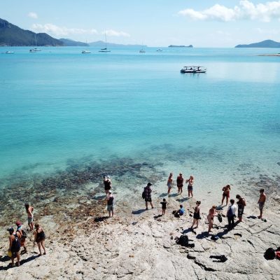 a group of people on a beach near a body of water