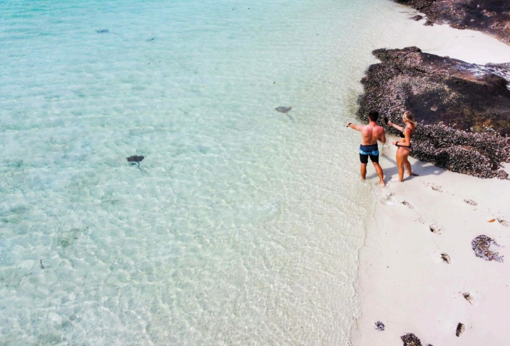 a man standing next to a body of water