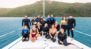 a group of people posing in front of a body of water