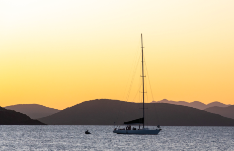 a boat in a large body of water with a mountain in the background