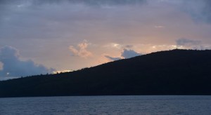 a large body of water with a mountain in the background