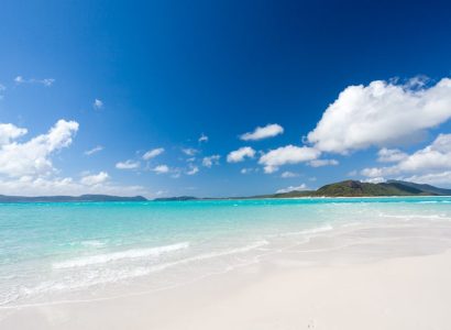 a sandy beach next to the ocean