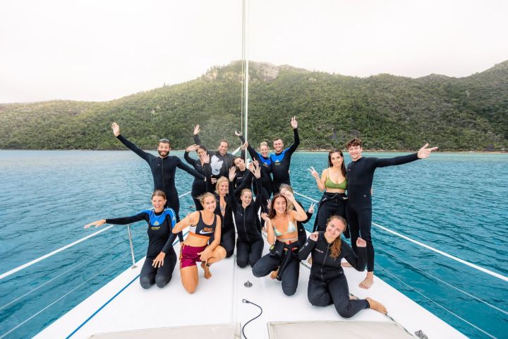 a group of people standing next to a body of water