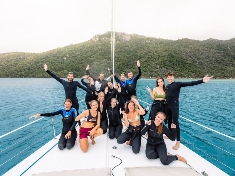 a group of people standing next to a body of water