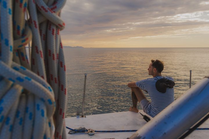 a person sitting on a beach near a body of water