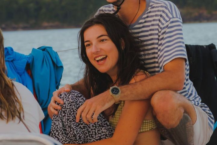a person sitting next to a body of water